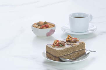 Coffee cake with toppings and black coffee on marble tabletop at coffee shop