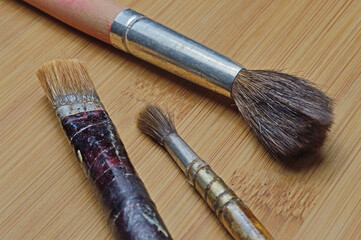 old art brushes on a wooden surface. close-up.