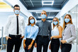 © Shopping King Louie - Successful team of business workers, wearing medical protective masks on their face, posing together in a modern office, happy motivated employees demonstrating unity and success, teamwork