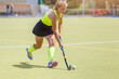 Younf female hockey player leading the ball
