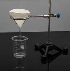 Filter paper in laboratory. Scientists are chemical filtration by filtering through filter paper in a glass funnel, Close up.