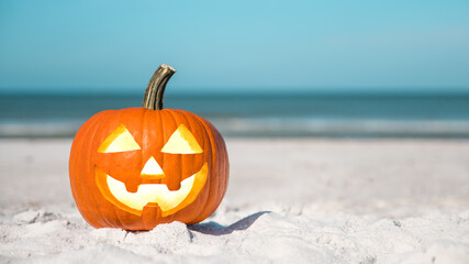 Halloween party on the beach. Pumpkin Jack-o'-lantern. Jack o lantern for Happy Halloween. Autumn season. On background ocean. Autumn in Florida. Fall season. Copy space.