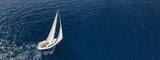 Aerial drone ultra wide photo of sailboat cruising deep blue sea