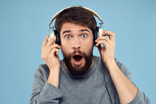 Man With Headphones In Hands Music Emotion Technology Lifestyle Fun Blue Background Close-up