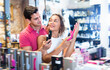 © JackF - Glad cheerful smiling couple of woman and man buyers choosing color sexy toys in the sex shop