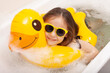 happy funny kid bathes in a bathtub with an inflatable duck
