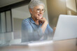 © goodluz - portrait of a beautiful 55 year old woman with white hair working from home