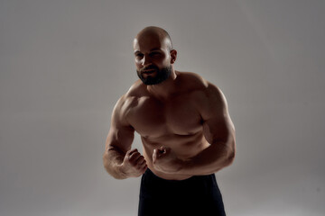 Poster - Muscular strong caucasian man bodybuilder showing his perfect body, chest, biceps, abs and looking aside while posing shirtless isolated over grey background