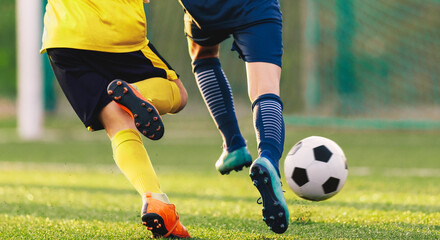 Wall Mural - Close-up of Two Youth Footballers Running in a Duel. Soccer Players in Football Cleats