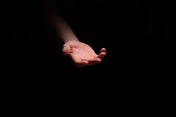 support hand on a dark background. helping hand from the dark