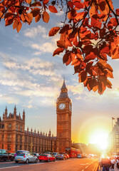 Fototapete - Big Ben against colorful sunset with autumn leaves in London, England