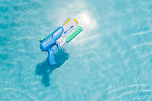 A Child's Blue Water Gun Floats In The Pool. A Toy For Playing In The Pool Or On The Beach