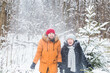 © satura_ - Love, season, friendship and people concept - happy young man and woman having fun and playing with snow in winter forest