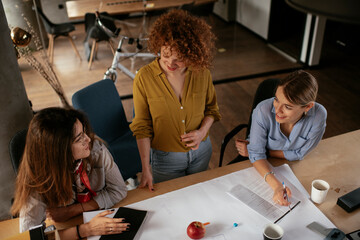 Poster - Businesswomen working on a new project. Colleagues discussing about problem they have to solved..