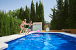 © Cavan Images - Two children bathe in a pool on a sunny summer day.
