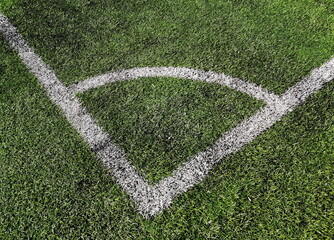 White line on the green grass of sporting stadium. Artificial sports surface green grass imitation on the football stadium