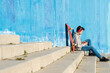 © Cavan Images - Teenager with headphones listening music while sitting on staircase.