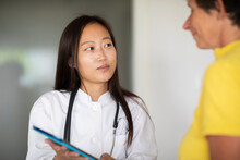 Young Asia Female Doctor Woman And Patient With Report In A Practice