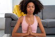 © Bisual Photo - Afro American woman practicing yoga lotus pose to meditation at cozy home