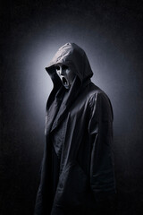 Wall Mural - Scary figure with mask in hooded cloak in the dark