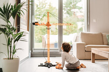 Little Toddler Boy Playing With Big Construction Building Crane Toy At Home In Living Room. Child Leisure Activity, Creative Game, Using Imagination.