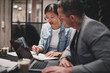 © Flamingo Images - Two businesspeople sitting at a table and going over paperwork