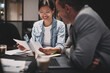 © Flamingo Images - Businesswoman discussing paperwork with a colleague during a mee