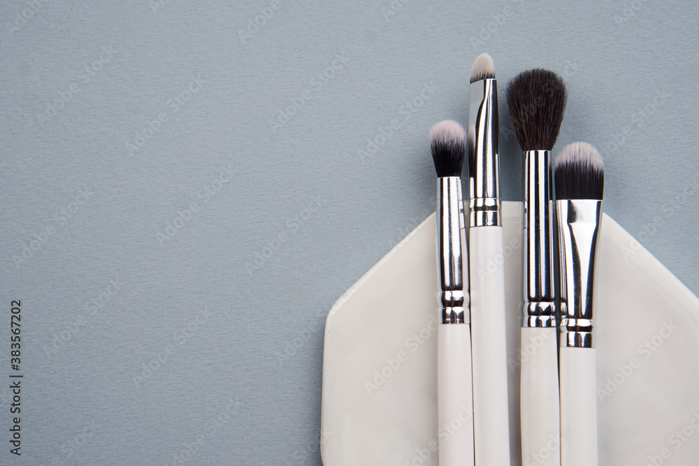 makeup brushes on gray background and stand cropped view Copy Space - obrazy, fototapety, plakaty 