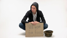 Poverty And Unemployment Concept. Poor Man With Cardboard Sign Ready To Work For Food. Isolated On White Background.