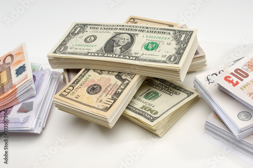 Cuadros en Lienzo Stack of US, British and European currency over white background