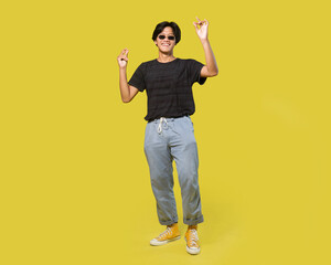 young asian man with black sunglasses dancing isolated on yellow background. with clipping path