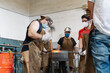 © Cavan Images - Crop men forging metal in workshop