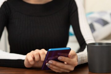 girl with a smartphone at a table in a cafe