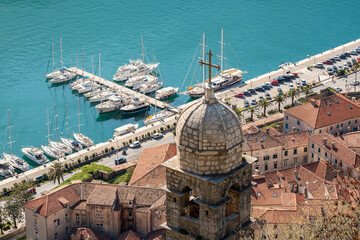 Aerial view of church of Our Lady of Remedy in Kotor old Town by the Adriatic sea. Yachts and boats docked to the pier in Kotor Bay. 