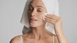 © Anton - Beautiful girl with towel on head using cotton sponge over white