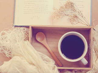 Black coffee and spoon on wooden tray with book, retro filter ef