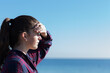 © Caro Telfer/Austockphoto - Teenage girl shading her eyes,looking out to sea