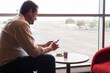 © Gillian Vann/Austockphoto - man using phone whilst waiting in airport lounge