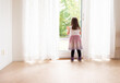 © Trygve - Girl standing by a glass door looking out