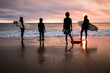 © Kellie Baldwin/Austockphoto - Rear view of family enjoying beach during sunset