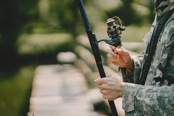 A man fishing on a lake. Guy in a uniform.