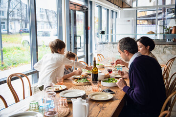 A family of four are having lunch on a spacious porch.