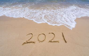 Wall Mural - 2021 year message handwritten in sand on beautiful beach background. New Years concept.