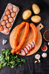 Canvas Print - fresh homemade sausage on a dark background with vegetables