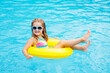 © famveldman - Child in swimming pool on toy ring. Kids swim.