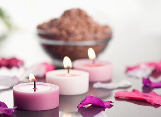 Canvas Print - Close up of lighted candles with a brown gravel bowl and petals