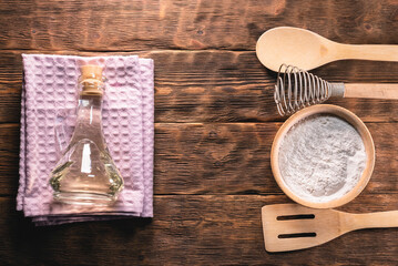 Wall Mural - Flour in the bowl, spatula oil bottle and towel on the kitchen table background.