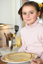 Little Girl Holding Plate Of Pancakes