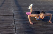 © splitov27 - Attractive young fitness woman practicing push-up exercise on the beach at sunrise