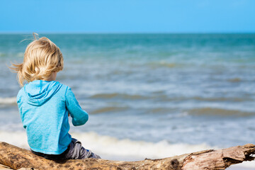 Young child sitting at the beach